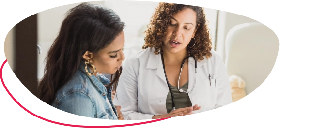A woman with a healthcare professional looking at something on a clipboard