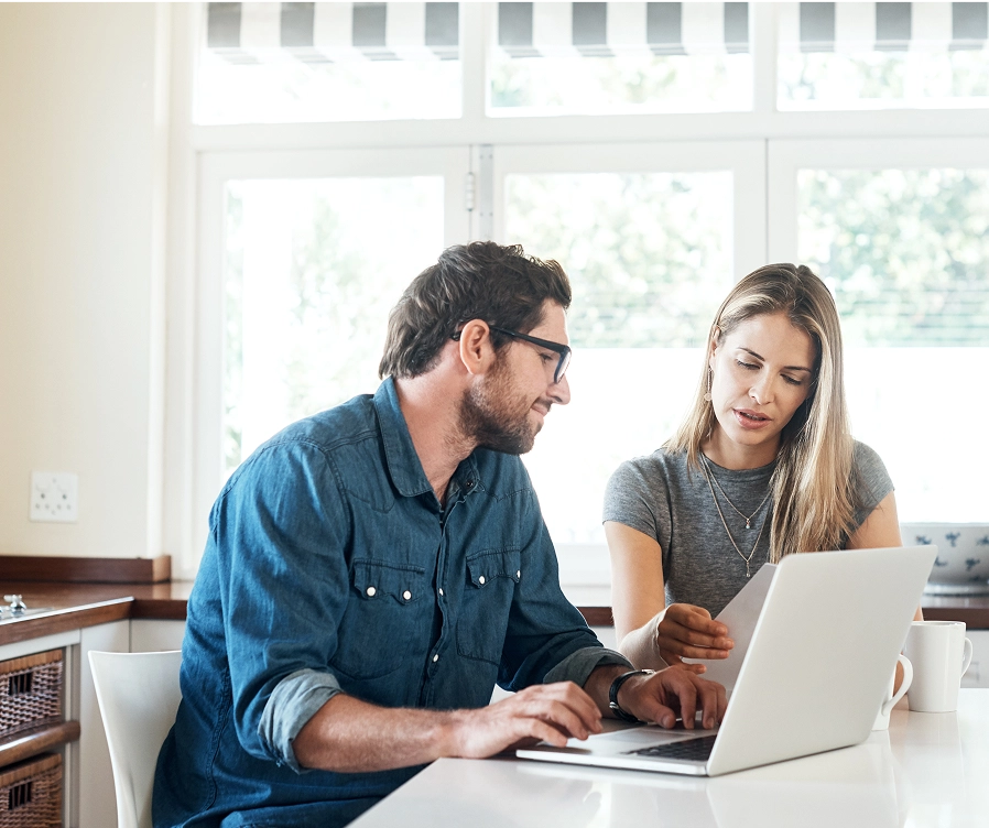 A man and a woman sitting with a laptop at a desk
