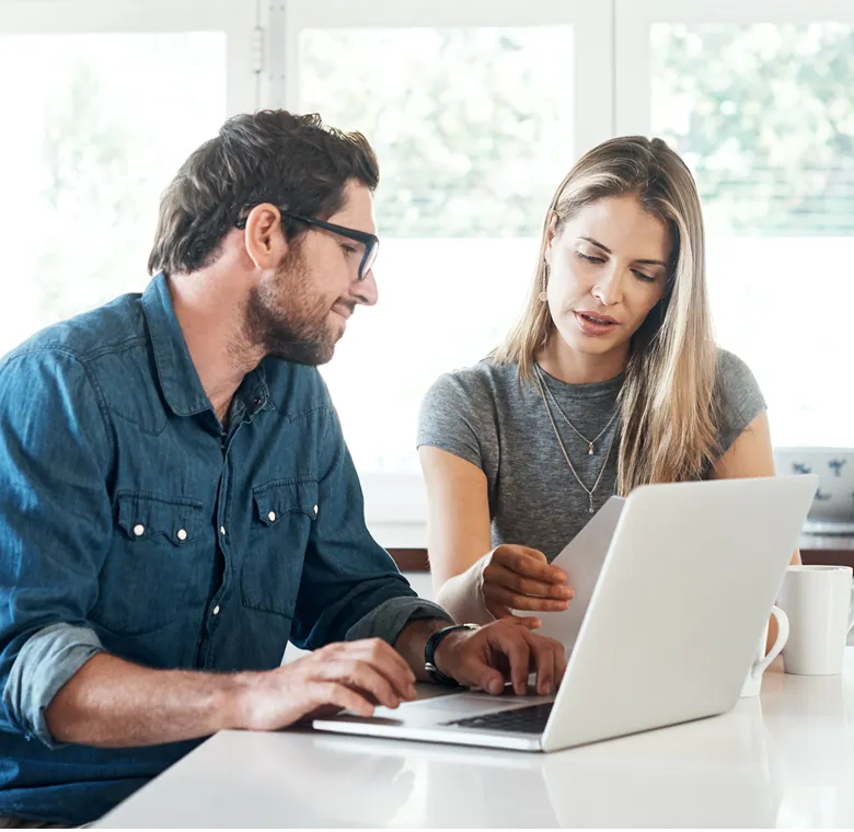 A man and a woman sitting with a laptop at a desk