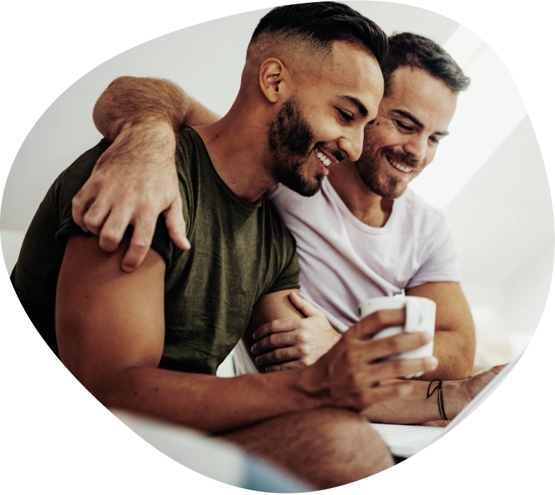 Two men sitting together embracing